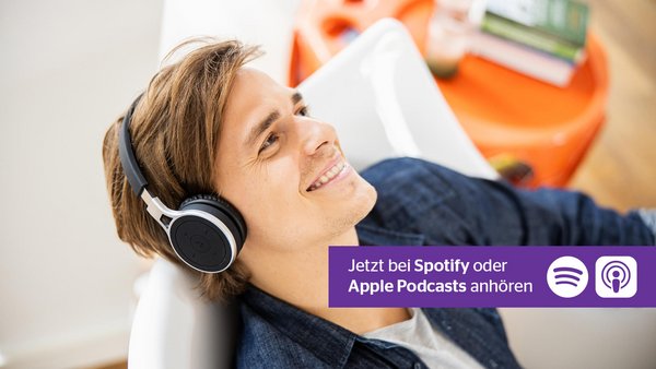 Junger Mann hört Podcast mit Kopfhörern
