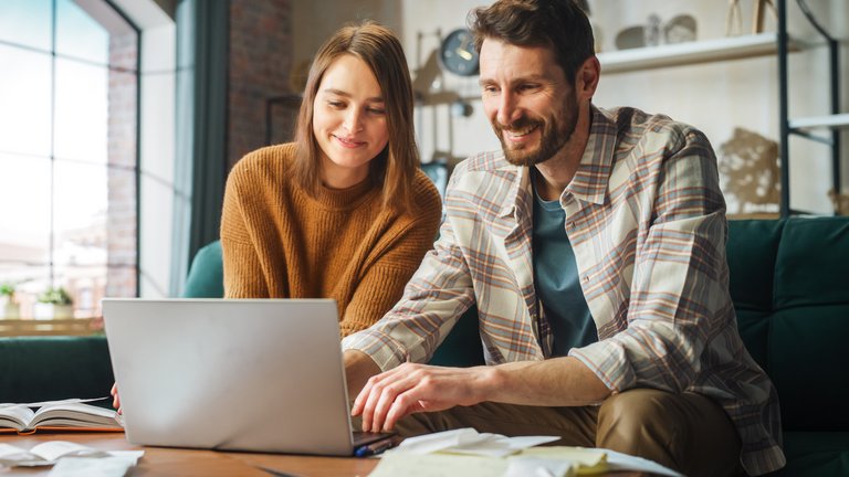 Ein Paar informiert sich gemeinsam am Laptop über die Kosten einer Finanzberatung.