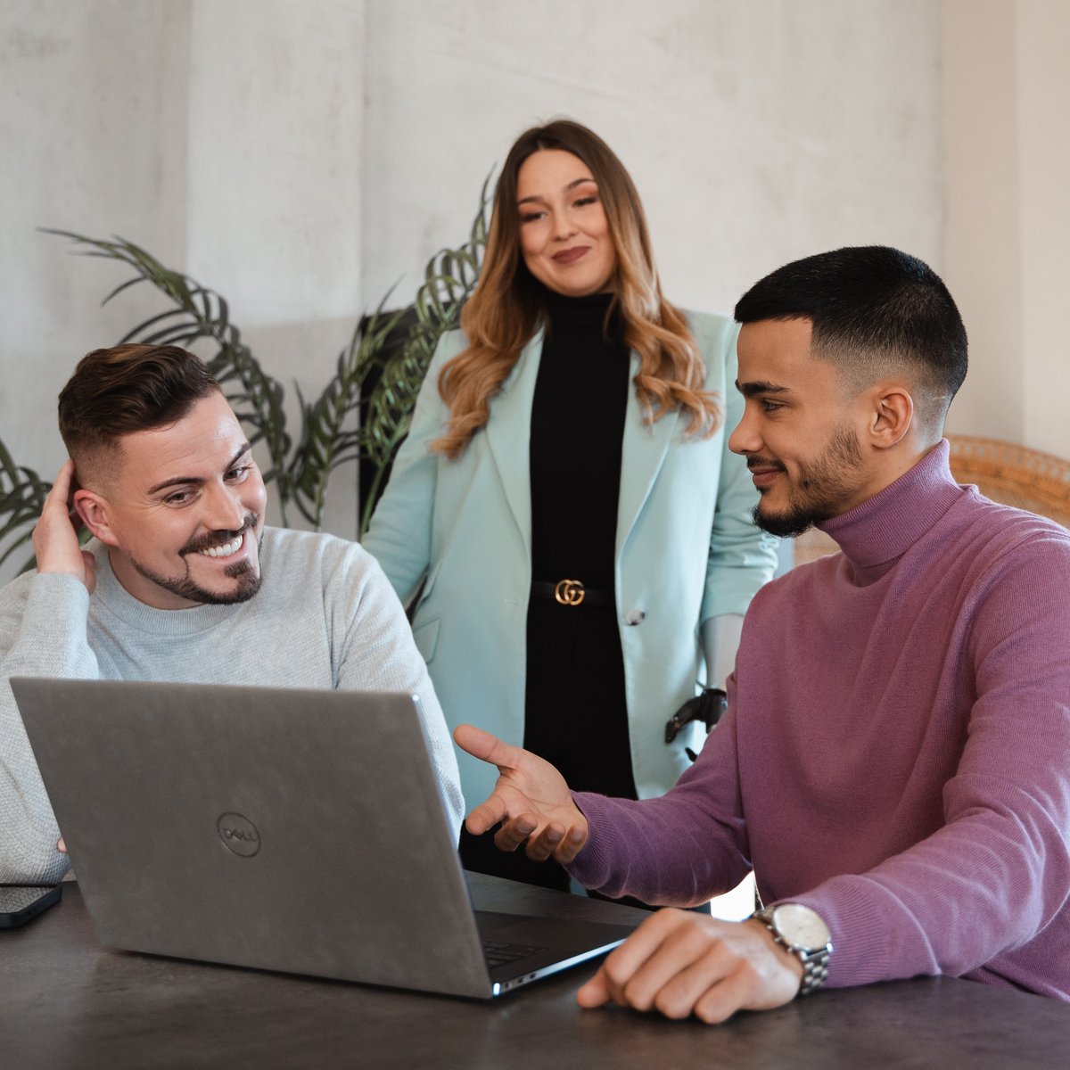 Drei Personen besprechen gemeinsam etwas am Laptop.