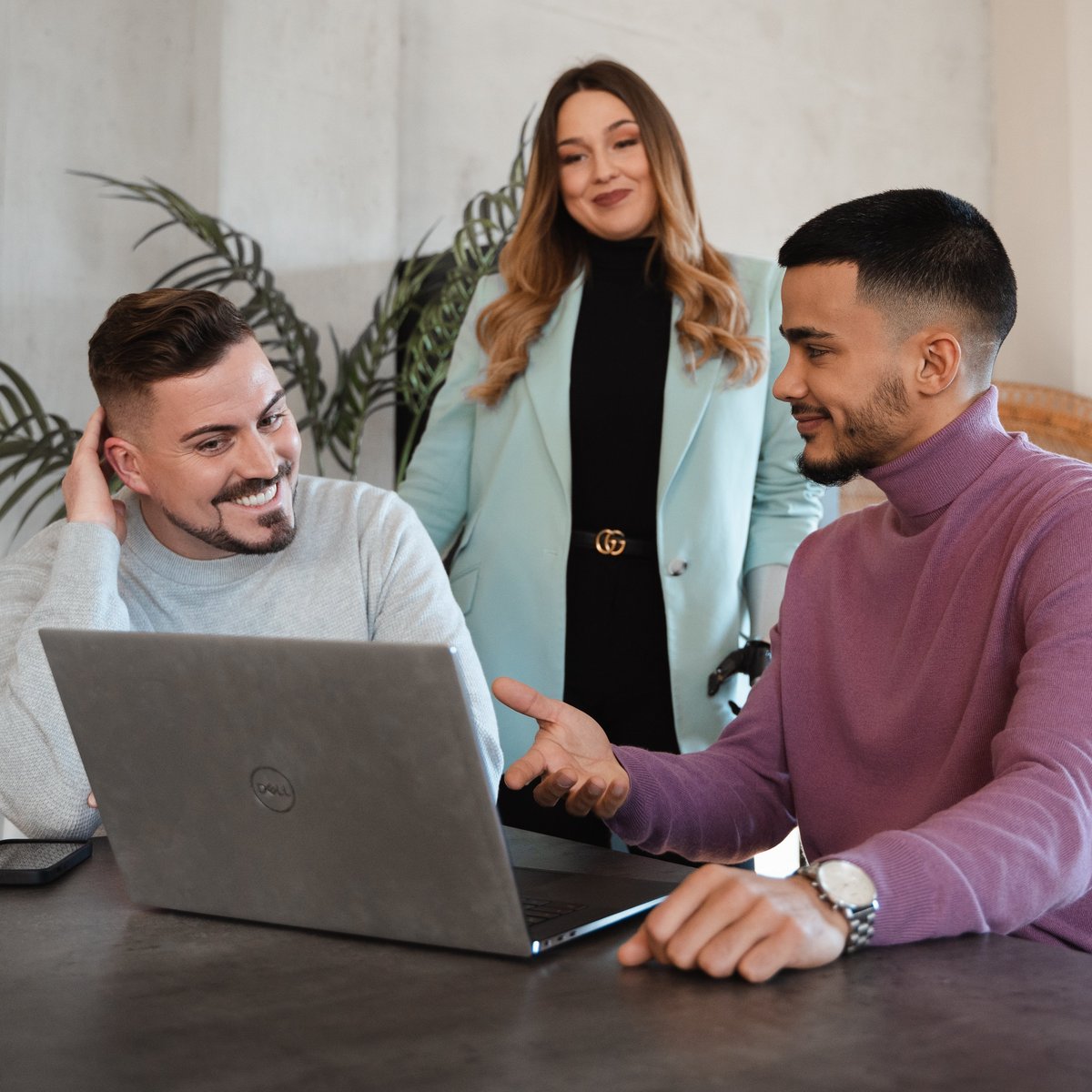 Drei Personen besprechen gemeinsam etwas am Laptop.