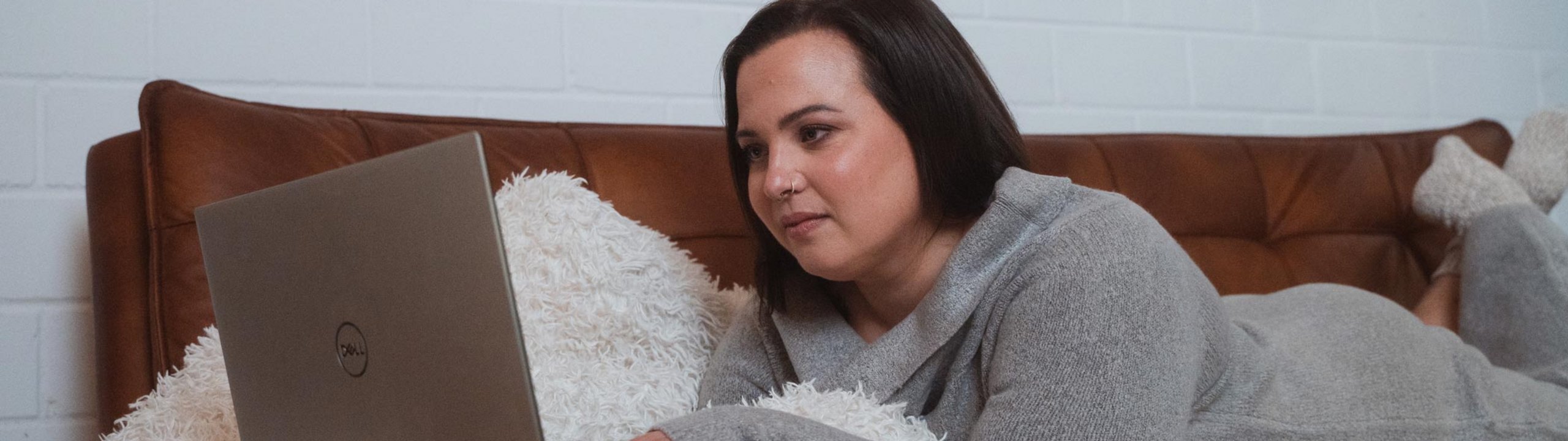 Eine Frau liegt im Bett und checkt ihr Depot