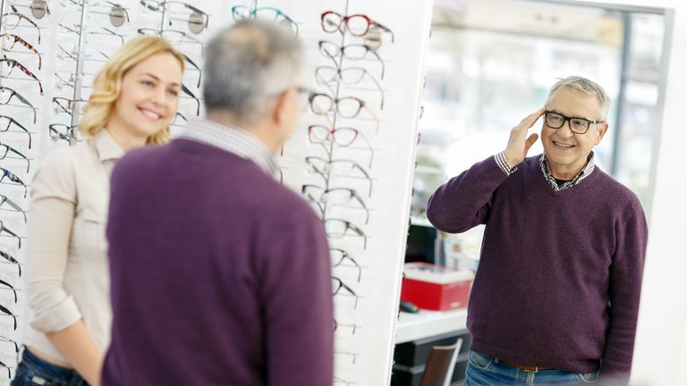 Mann probiert Brille beim Optiker an.