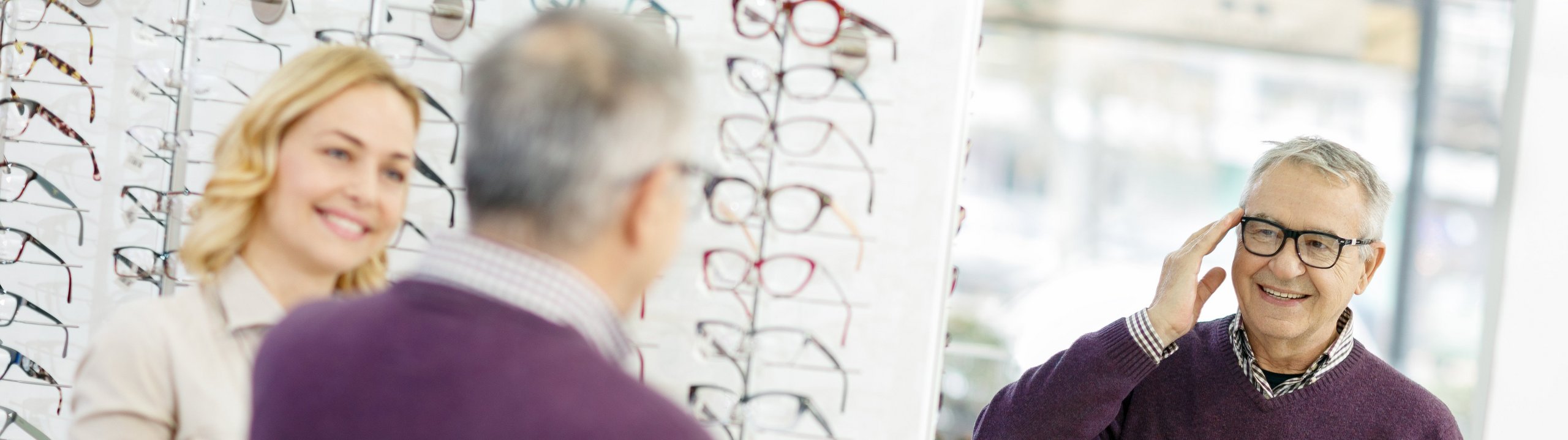 Mann probiert Brille beim Optiker an.