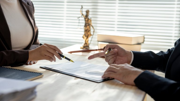 Zwei Personen besprechen ein Dokument am Schreibtisch.