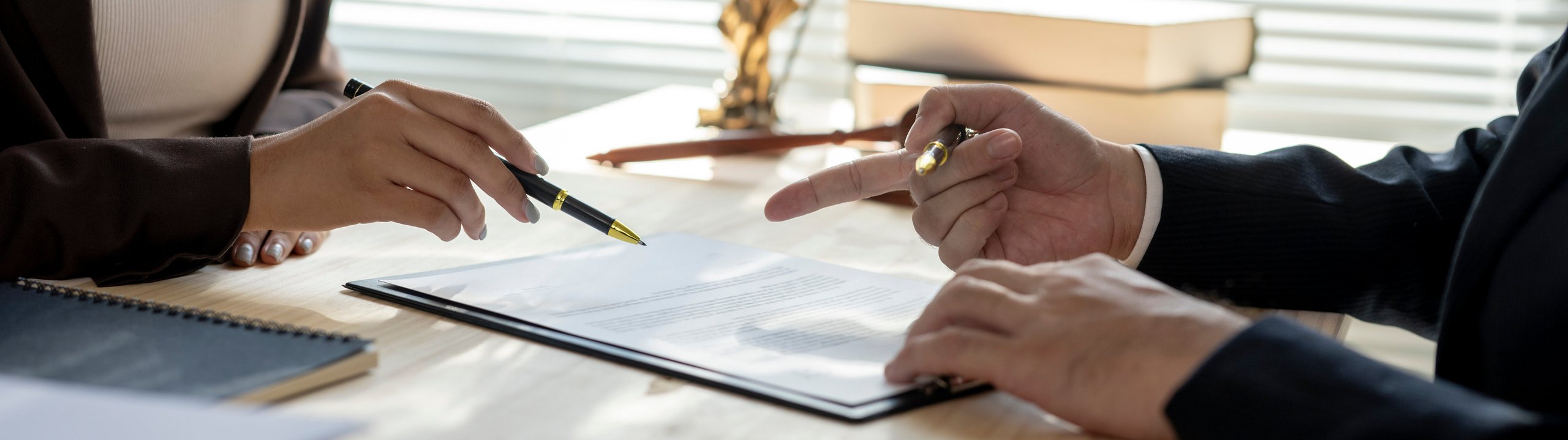 Zwei Personen besprechen ein Dokument am Schreibtisch.