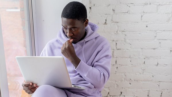 In 5 Schritten zu deiner Altersvorsorge Student sitzt grübelnd vor einem Laptop