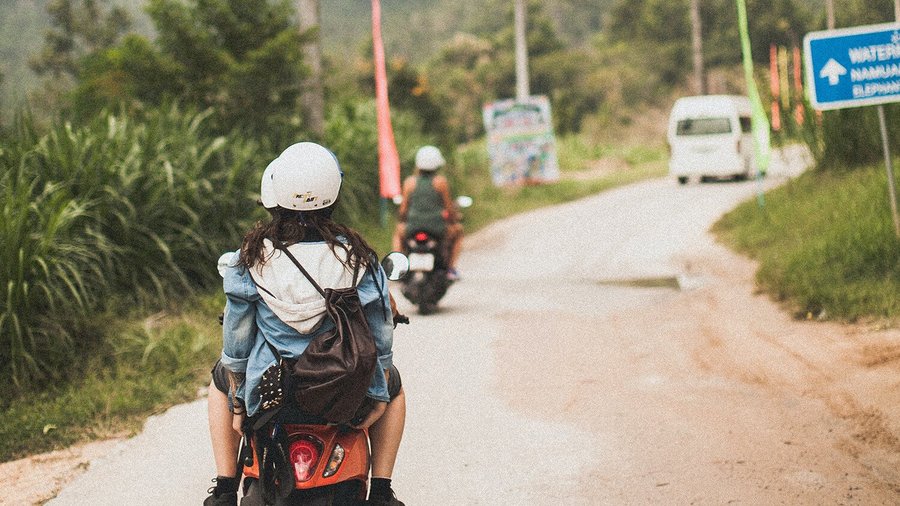 Junge Frau auf einem Roller – Backpacking im Ausland