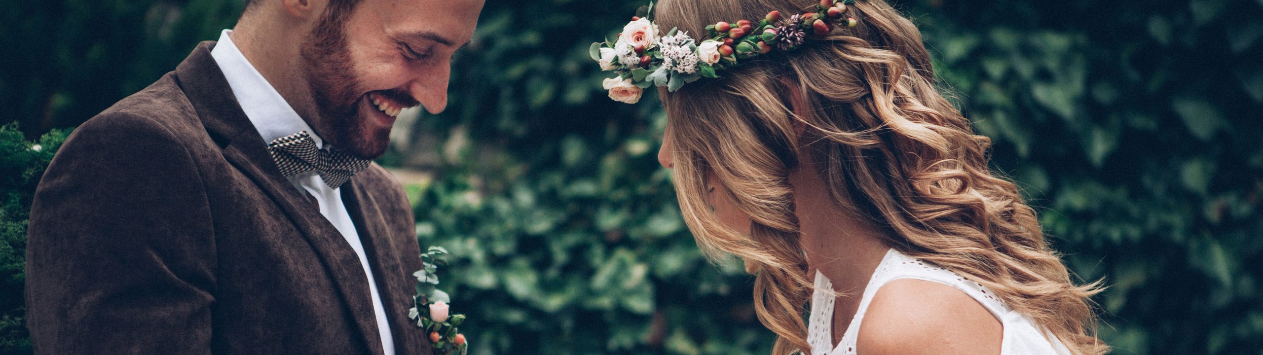 Brautpaar betrachtet bei ihrer Hochzeit die Ringe an ihrer Hand.