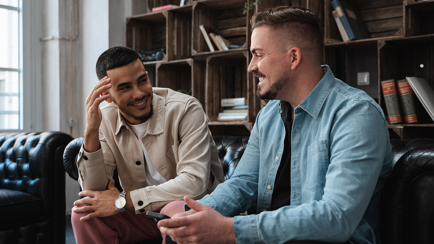 Zwei Studenten reden miteinander auf einer Couch 