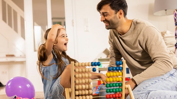 Vater und Tochter rechnen mit einem Abakus