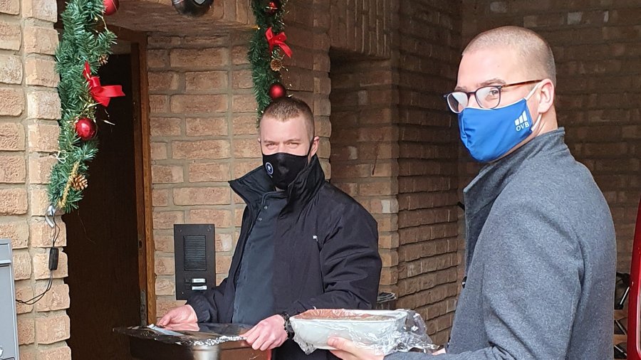 2 Mitarbeiter der OVB Regionaldirektion Ahrweiler stehen vor Haustür mit Gesichtsmaske um Essen an Weihnachten zu liefern