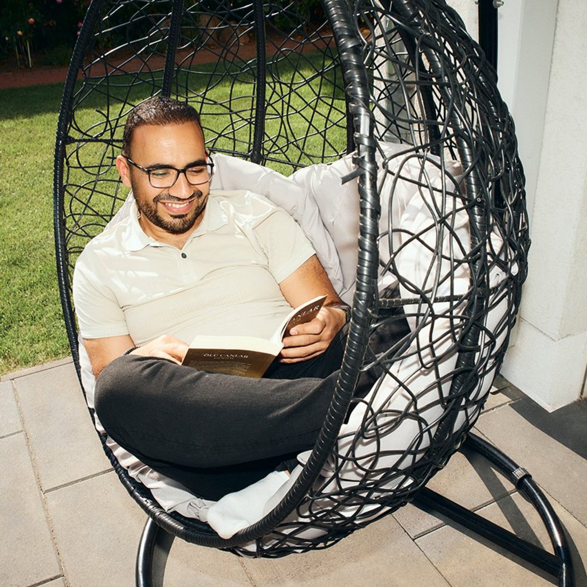OVB-Kunde Ekrem sitzt in Outdoor-Sessel mit einem Buch
