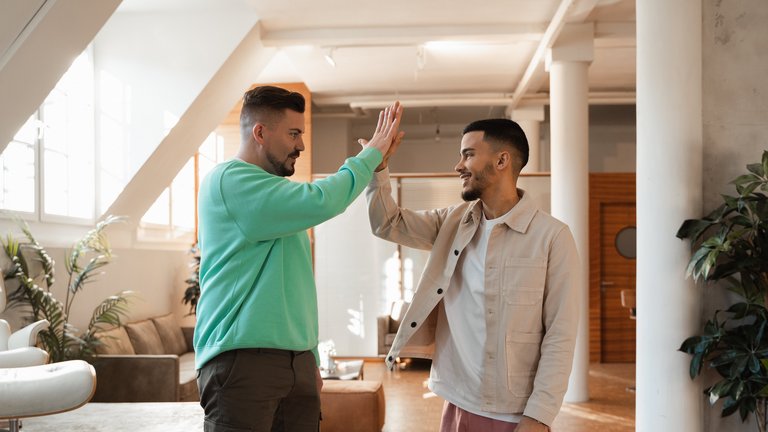 Zwei junge Männer geben sich ein High-Five.