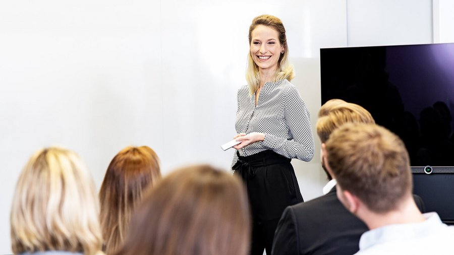 OVB Finanzberaterin präsentiert vor einer Gruppe Finanzberater