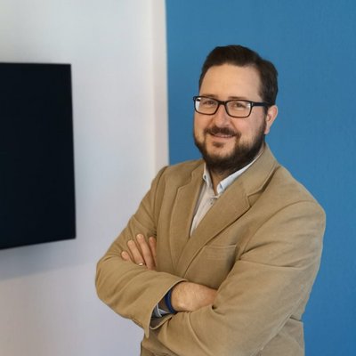 Florian Heuer vor blauer Wand als Portraitbild