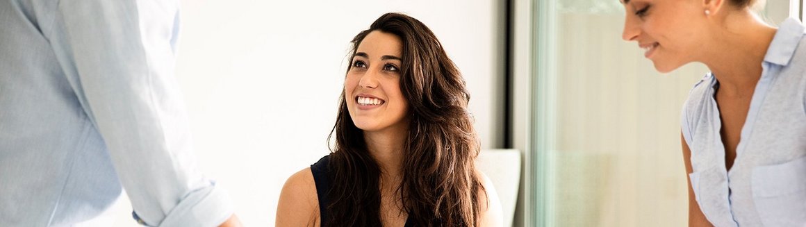 Frau mit Laptop in Teamarbeit