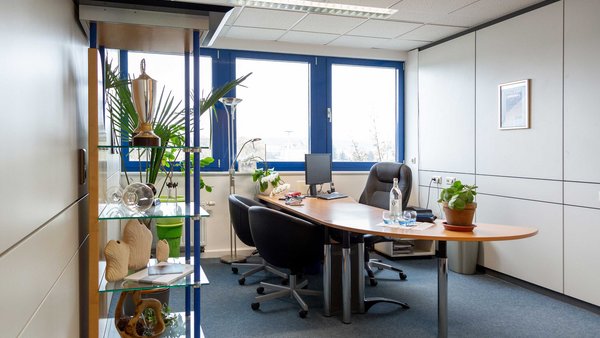 Büroraum mit Schreibtisch und Stühlen