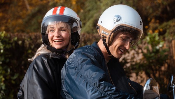 Junges Paar fährt zusammen Motorroller.
