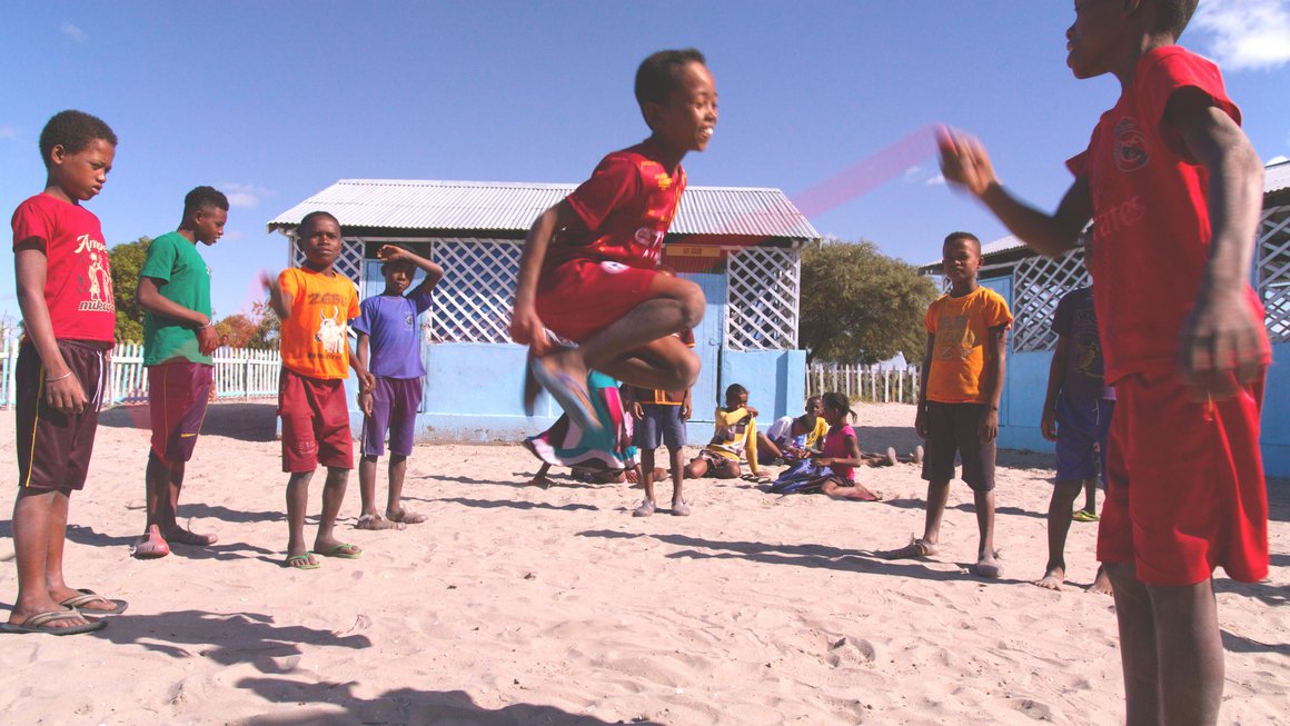 Mehrere Kinder in Madagaskar springen Seil am Strand
