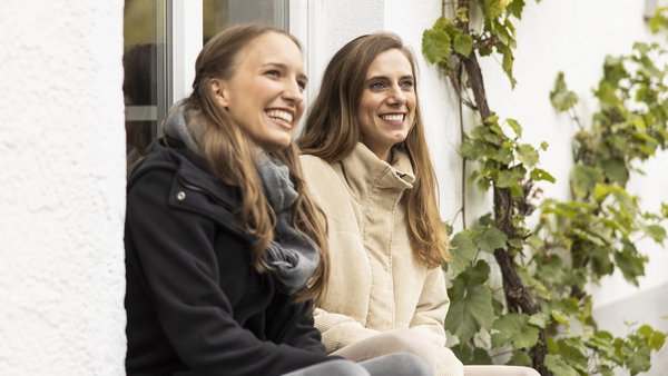 Glückliche Freundinnen am Haus OVB