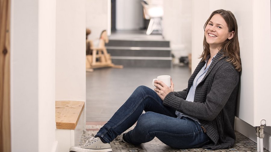 Junge Frau macht Pause vor eigener Wohnung OVB