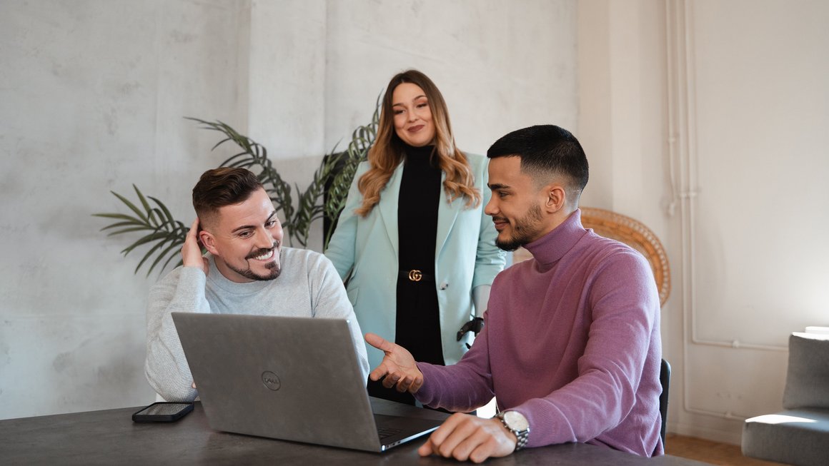 3 Menschen vor einem Laptop