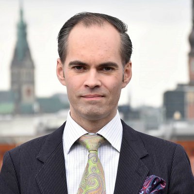 Berater steht auf Terasse, vor Kirche