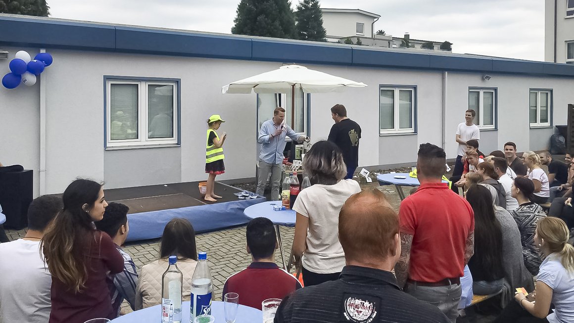 OVB Landesdirektor Martin Wagner organisiert Tombola mit vielen Teilnehmern in einem Innenhof