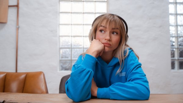 Junge Frau blickt nachdenklich.