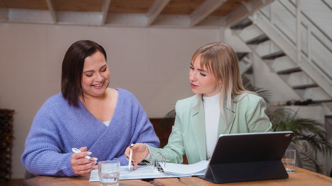 zwei Frauenm sitzen am Laptop