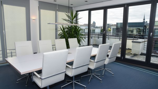 Konferenzraum, großer Tisch mit Bürostühlen drum herum