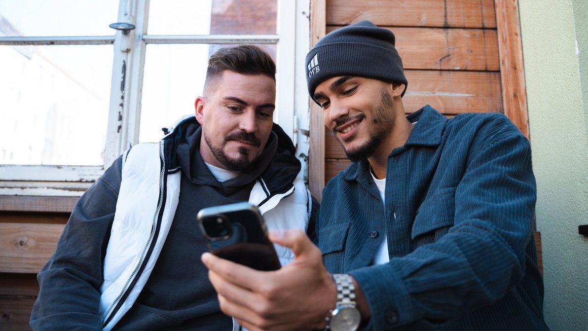 zwei Männer schauen auf Smartphone zwei Männer schauen auf Smartphone