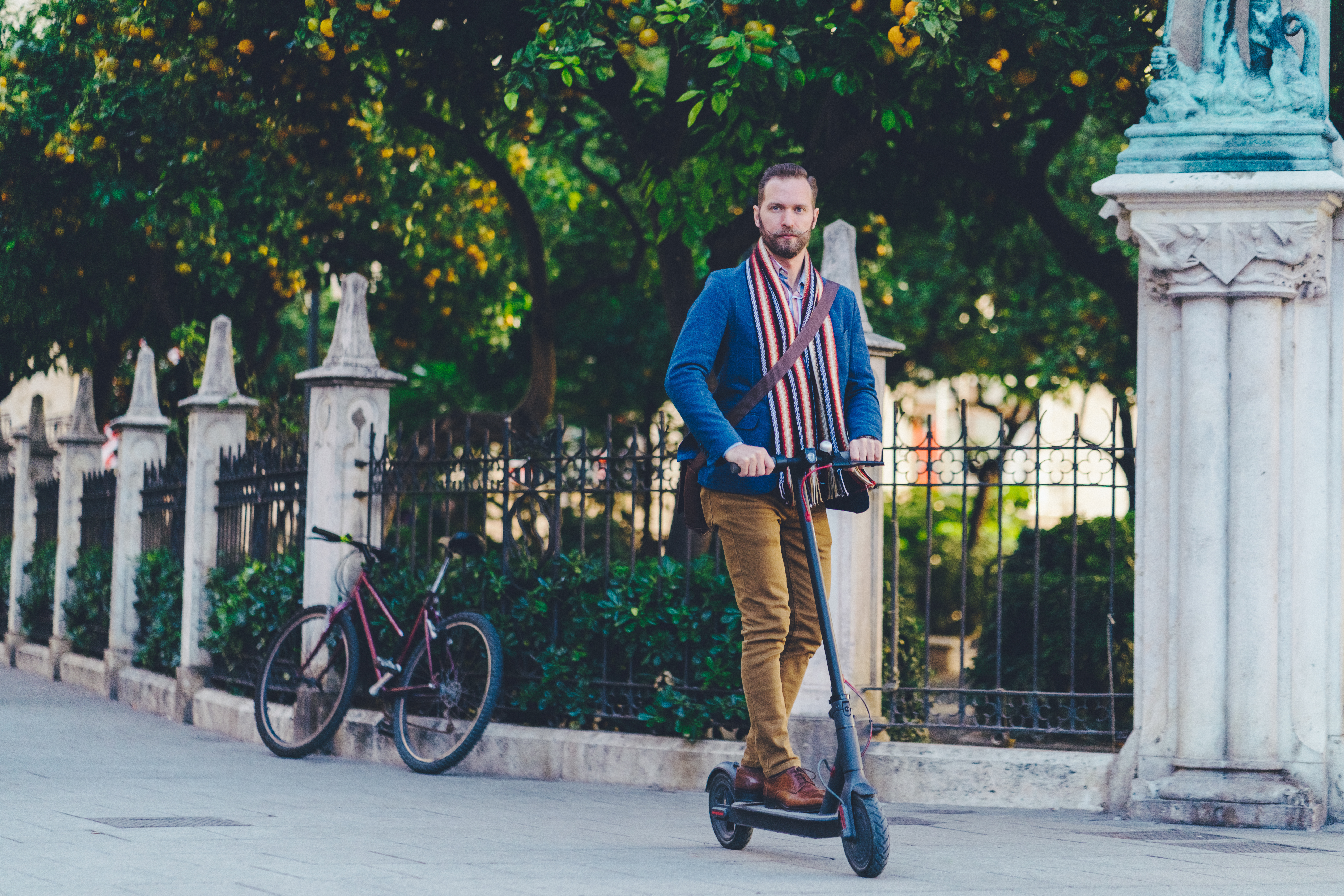 Mann mit Bart fährt E-Scooter - Elektromobilität