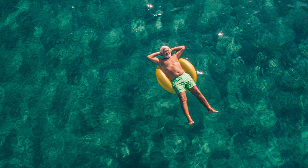 Altersvorsorge Altersvorsorge: Rentner entspannt mit Schwimmreifen auf dem Wasser