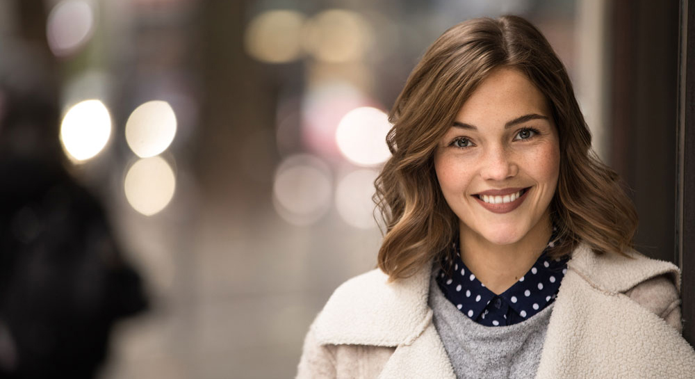 Was einen fairen Arbeitgeber ausmacht Fairer Arbeitgeber: Frau lächelt zufrieden