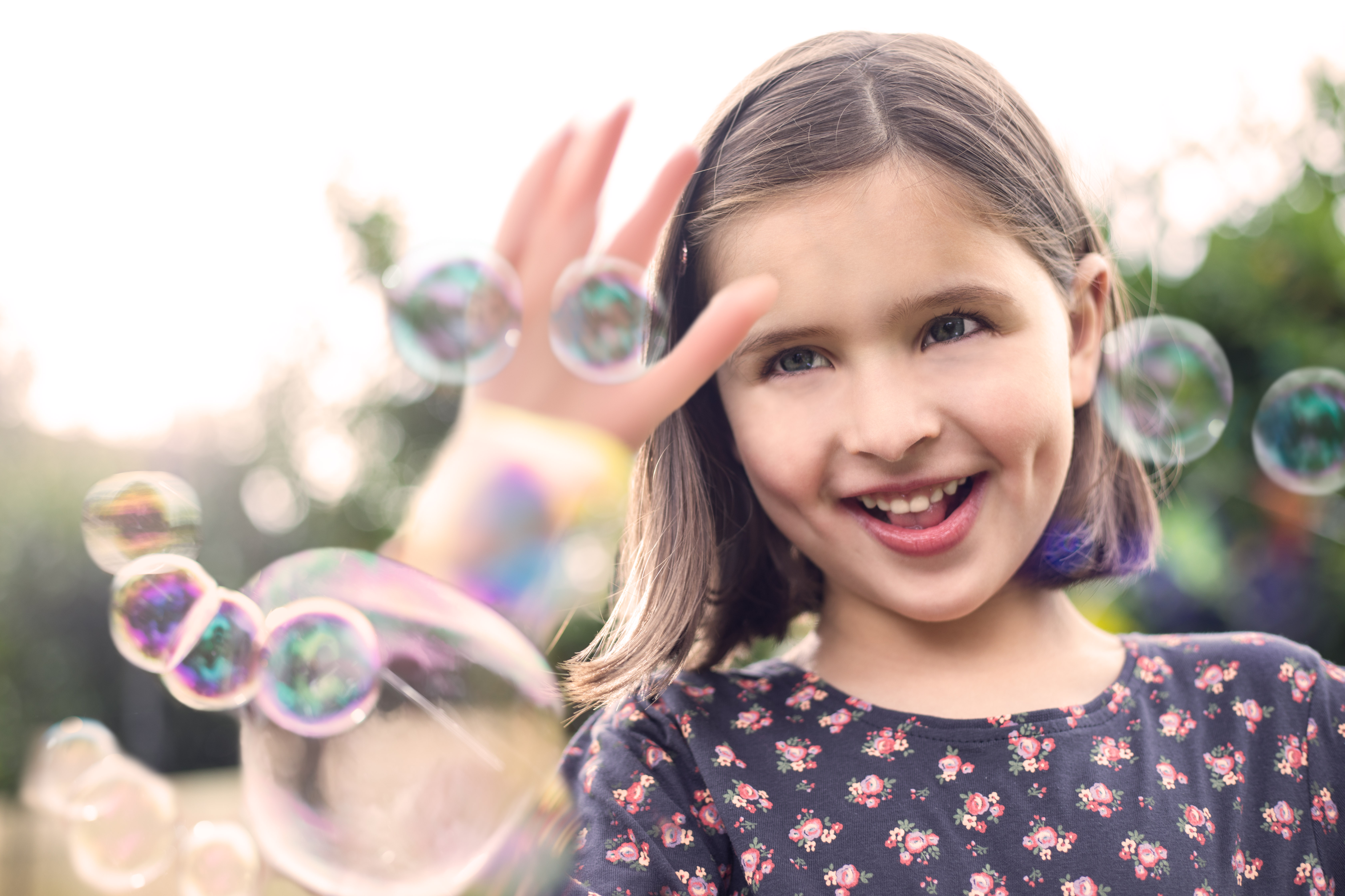 Junges Mädchen in Nahaufnahme fängt Luftblasen im Sommer