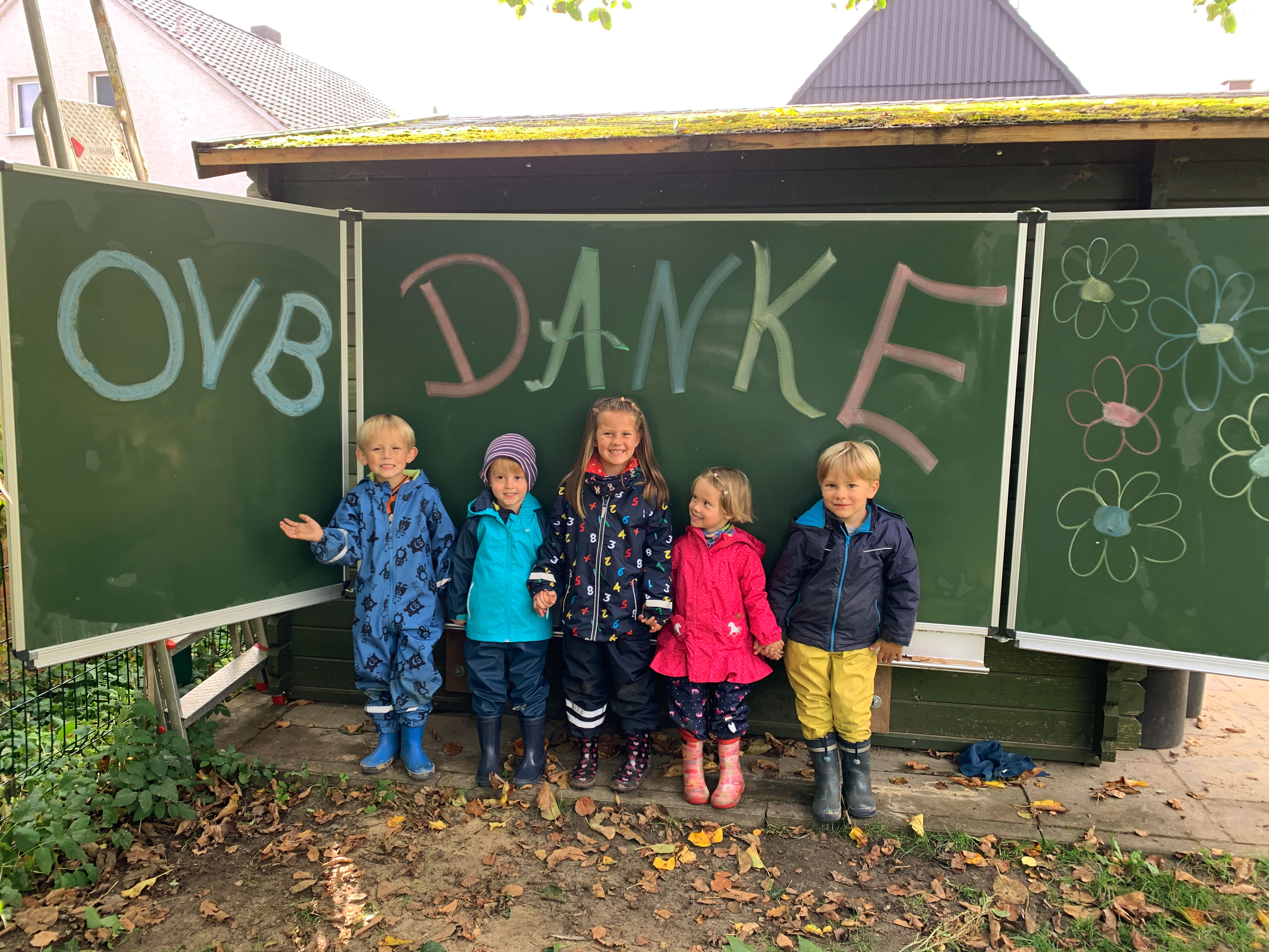 Fünf Kindergartenkinder stehen vor Tafel auf der Danke OVB steht